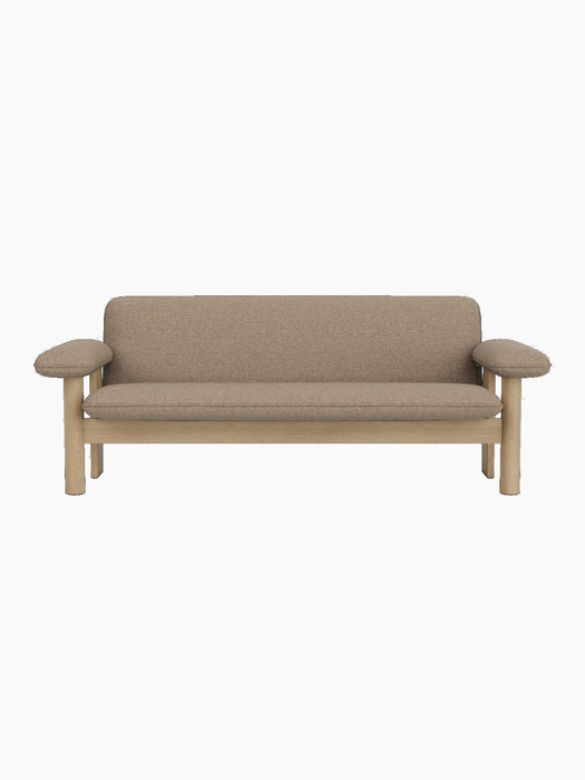 Front view of the Brasilia Sofa. The two-seater has a natural oak frame with rounded legs and exaggerated, padded armrests.