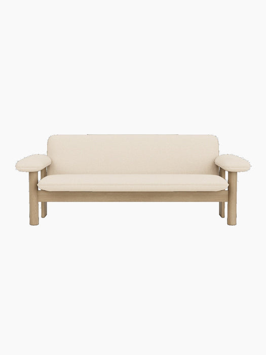 A front-on view of the Brasilia Sofa, featuring a natural oak frame with rounded armrests and plush Logan Jasmine upholstery.