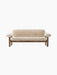 Front view of the Brasilia Sofa with a natural wood frame and off-white sheepskin upholstery against a black background.