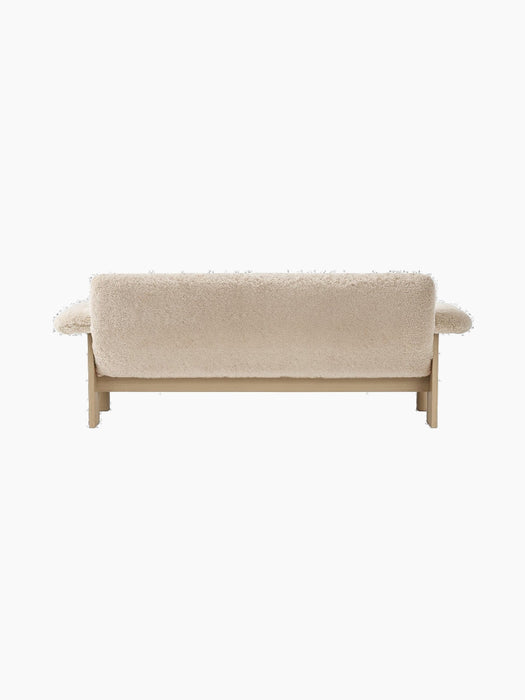 Back view of the Brasilia Sofa in Sheepskin, showing its low back, plush light-coloured upholstery and natural oak frame.
