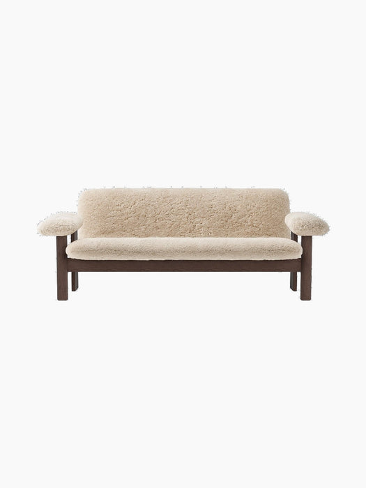 Front view of the Brasilia Sofa, Sheepskin. Features a dark wood frame and plush, off-white sheepskin upholstery.