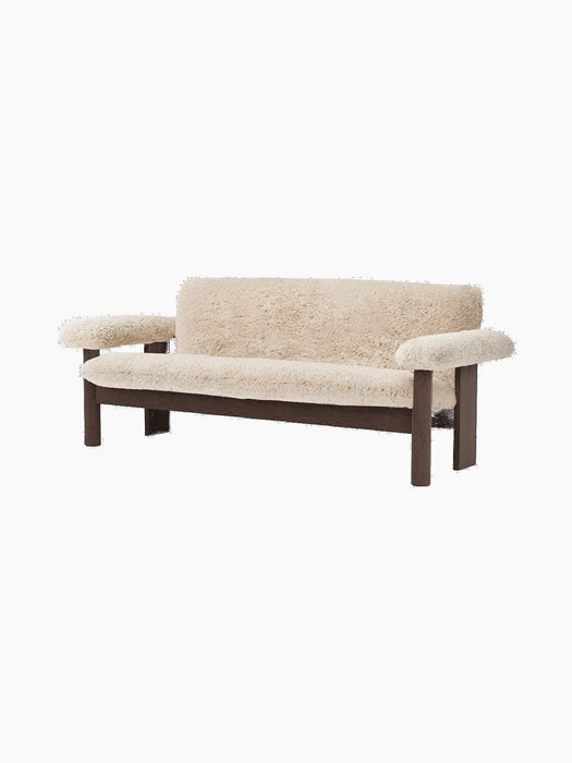 Front angle view of the Brasilia Sofa upholstered in plush, light beige Sheepskin with a sturdy, dark-stained wooden frame.