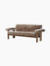 The Brasilia Sofa in brown sheepskin, shown from the front. It has a dark wood frame, low back and large rounded armrests.