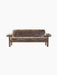 Front view of the Brasilia Sofa in plush brown sheepskin with a wooden frame and legs, against a black background.