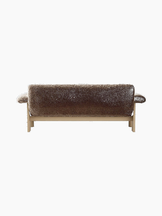 Back view of the Brasilia Sofa, upholstered in plush brown sheepskin with a visible light oak frame and rounded armrests.