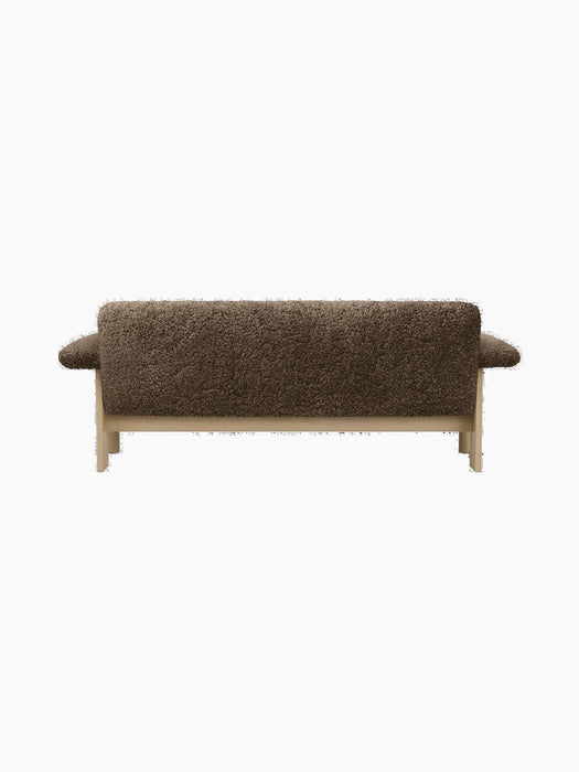 Back view of the Brasilia Sofa, upholstered in textured brown sheepskin, featuring a low back and a natural light oak frame.