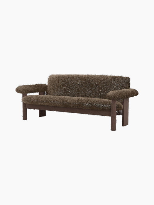 Brasilia Sofa upholstered in dark brown sheepskin, featuring a dark stained wood frame with rounded legs and large armrests.