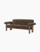 The Brasilia Sofa in dark brown sheepskin, with a dark wood frame and exaggerated, rounded armrests, shown from an angle.