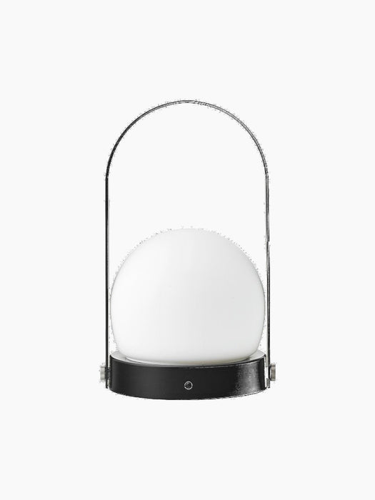 Back view of the black Carrie Portable Table Lamp features a matte black base, a white glass orb, and a thin metal handle.