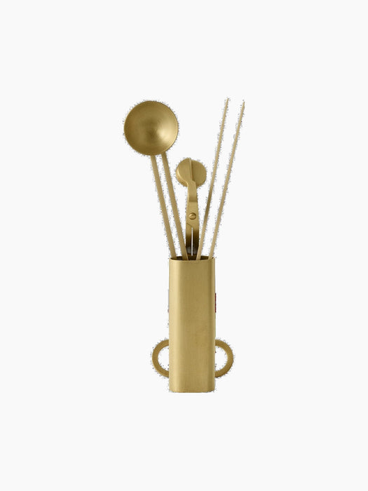 A brass Clip Candle Care Kit against a black background. The kit includes a snuffer, wick trimmer, and dippers in a holder.