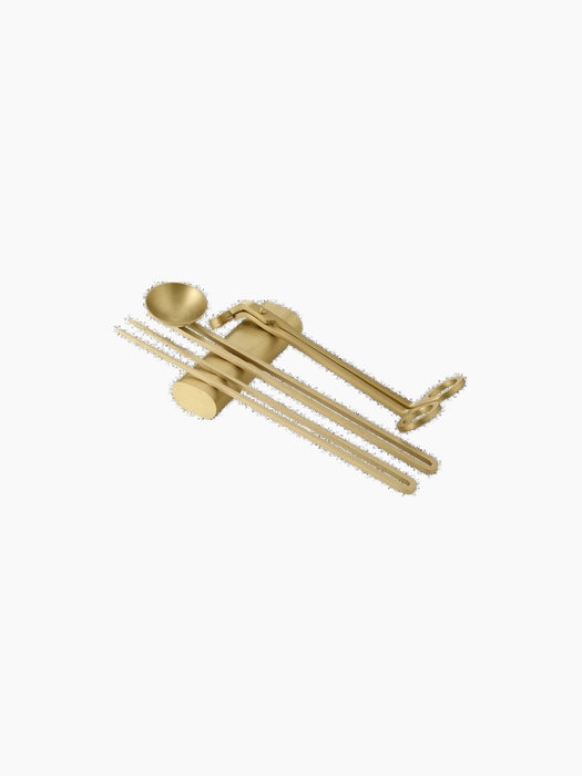 The Candle Care Kit in a brass finish, including a wick trimmer, a snuffer, and a dipper, isolated on a black background.