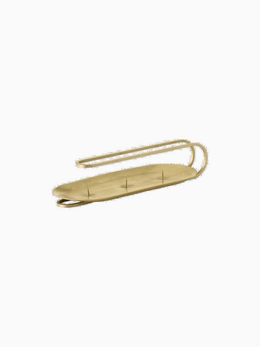 Angled view of the brass Clip Candle Holder Table 3-arm, a minimalist design with a curved handle and an oval base.