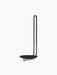Angled view of the minimalist black Clip Candle Holder for walls, with a sleek, looped frame and a small dish for a candle.