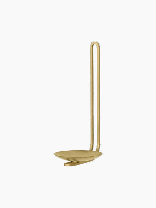 Angled view of the Clip Candle Holder H20 Wall in brass, with its looped handle and saucer base against a black background.