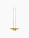 The brass Clip Wall Candle Holder viewed from the front, showcasing its tall, slender U-shaped handle and circular base.