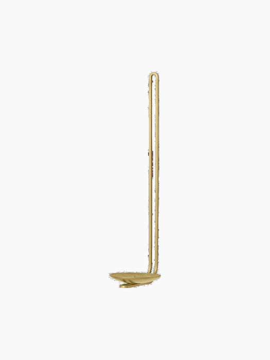 The Clip Candle Holder for walls, in brass, seen from an angle. It has a tall, slender design with a looped handle.
