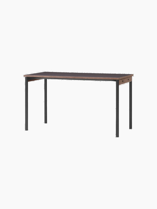 An angled view of the Co Table, featuring a rectangular terra laminate top, solid oak trim, and slender black steel legs.