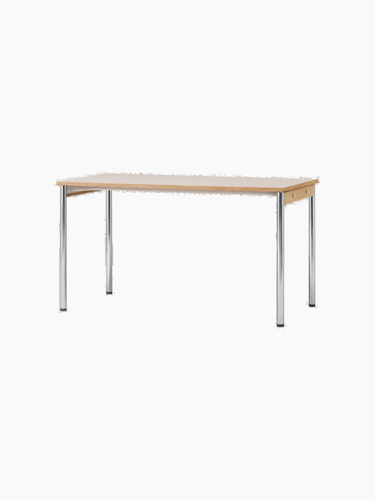 The rectangular Co Table, seen from an angle, with a creme laminate top, oak wood apron, and slender, shiny chrome legs.
