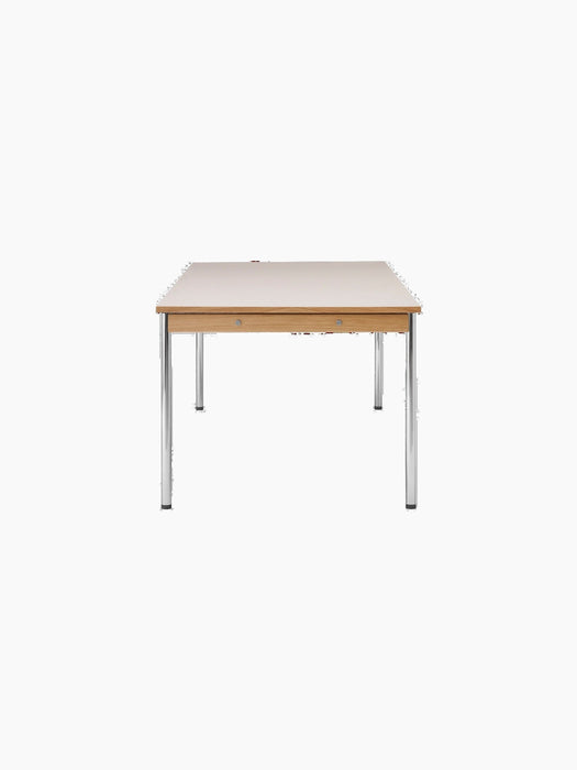 A side view of the rectangular Co Table, featuring a cream laminate top, a solid oak frame, and four slender chrome legs.