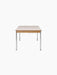 A side view of the rectangular Co Table, featuring a cream laminate top, a solid oak frame, and four slender chrome legs.