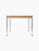 Side view of the rectangular Co Table with a creme laminate top, oak apron with decorative screws, and four slim chrome legs.