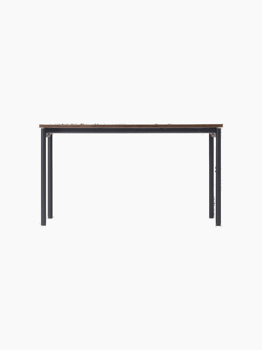 The Co Table shown from the front, featuring a dark brown Terra Laminate top and a simple, elegant frame made of black steel.