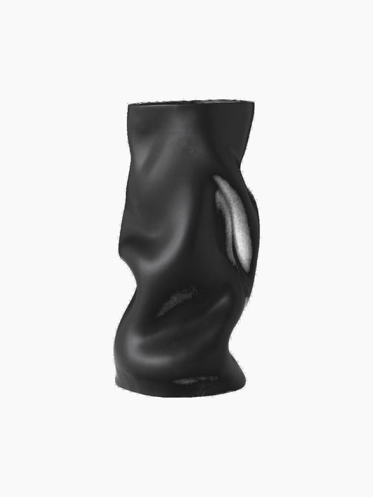 The black Collapse Vase, with a sculptural, organic silhouette. Its surface features soft, undulating folds.