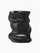 Angled view of the sculptural Collapse Vase in matte black. Its body is artfully crumpled and folded, creating soft shadows.