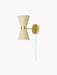 The Collector Wall Lamp in cream with a polished brass fixture. The illuminated hourglass shade has perforated details.
