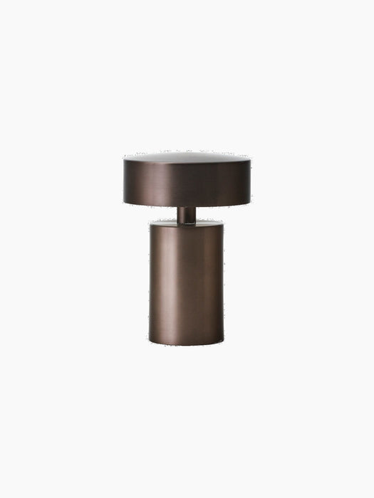 The portable Column Table Lamp in a bronzed aluminium finish. The mushroom-shaped lamp is shown against a black background.