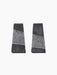 Studio shot of two trapezoid-shaped Converge Book Ends in dark lava stone, standing apart against a plain black background.