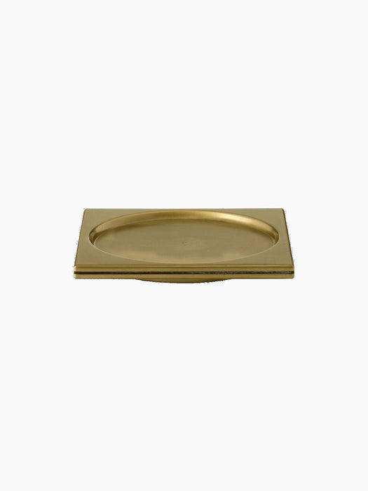 Front view of the Divot Tray in brass against a black background. The tray is square with a circular indented centre.