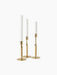 The Duca Candle Holder collection in polished brass. Three holders of varying heights with textured stems and white candles.