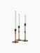 Three Duca Candlesticks in Bronzed Brass with rattan-wrapped stems holding white candles, shown against a black background.