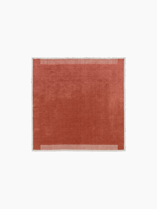 Aerial view of the square Duomo Rug in Terracotta Red with a thin, off-white border and decorative vertical stripe pattern.