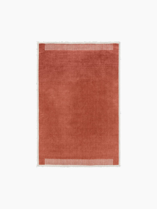Top view of the rectangular Duomo Rug in Terracotta Red. It has an off-white border with a striped pattern on the short ends.