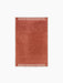 Top view of the rectangular Duomo Rug in Terracotta Red. It has an off-white border with a striped pattern on the short ends.