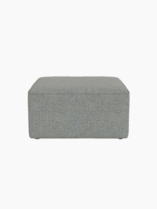 A front view of the Eave Modular Pouf, 75. The square pouf has textured, light blue and grey Safire 012 upholstery.