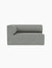 A front-on view of the Eave Modular Sofa, 86, Corner 129 in a light grey and blue textured fabric against a black background.