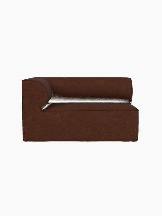 A profile view of the Eave Modular Sofa, 86, Corner 129 module in brown Audo Bouclé 08 fabric against a black background.