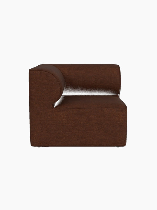 A side view of the Eave Modular Sofa 86 Corner section, upholstered in a textured, dark brown Audo Bouclé 08 fabric.