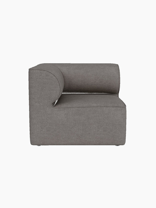 A front view of the Eave Modular Sofa 86 Corner in Audo Bouclé 16 fabric, showing its curved armrest on a black background.