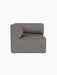 A front view of the Eave Modular Sofa 86 Corner in Audo Bouclé 16 fabric, showing its curved armrest on a black background.