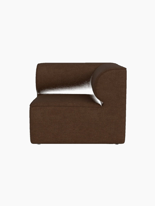 A side profile of the Eave Modular Sofa, 86, Corner piece in a brown Audo Bouclé 07 fabric against a black background.