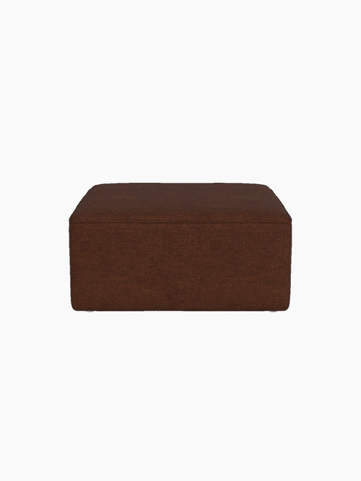 Side view of the Eave Modular Sofa Pouf, 86, upholstered in textured, brown Audo Bouclé 08 fabric against a black background.