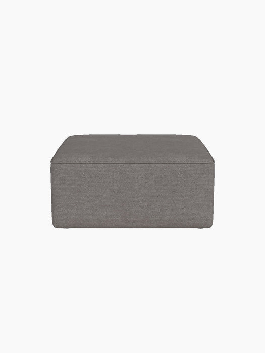 Eave Modular Sofa, 86, Pouf upholstered in a dark grey textured Audo Bouclé 16 fabric against a black background.