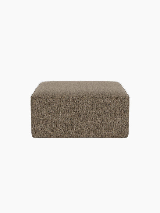 Front view of Eave Modular Sofa, 86, Pouf upholstered in a textured brown Safire 001 fabric, isolated on a black background.