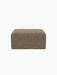 Front view of Eave Modular Sofa, 86, Pouf upholstered in a textured brown Safire 001 fabric, isolated on a black background.