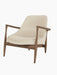 A side-angle view of the Elizabeth Lounge Chair with a dark walnut frame and light-coloured Hallingdal fabric upholstery.