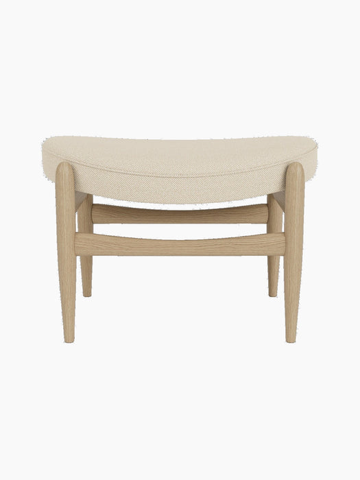Elizabeth Ottoman with a natural oak frame and a curved seat upholstered in light beige Hallingdal fabric.